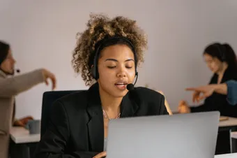 A support specialist taking a call at her desk
